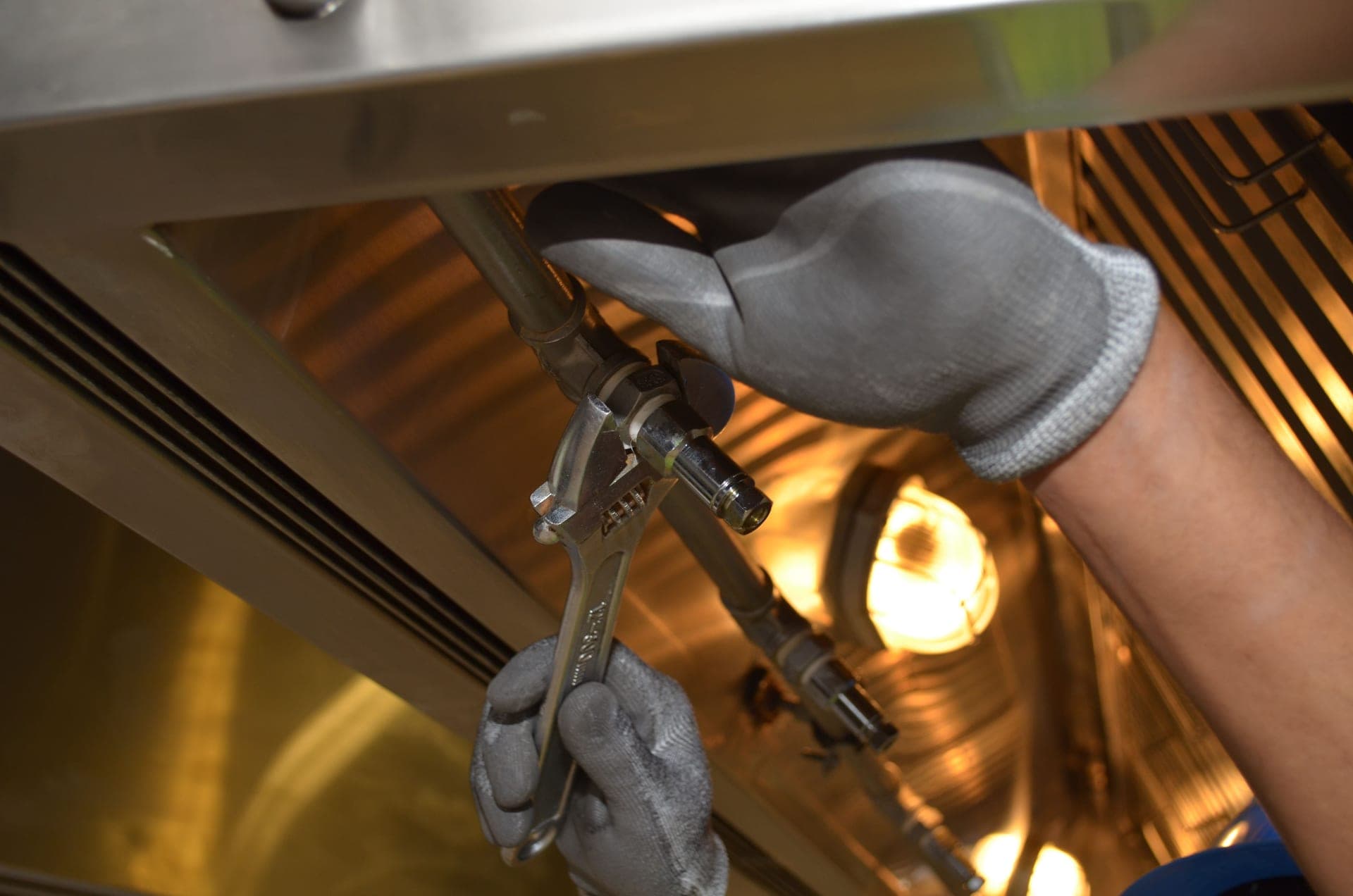A plumber working on a pipe under a kitchen sink